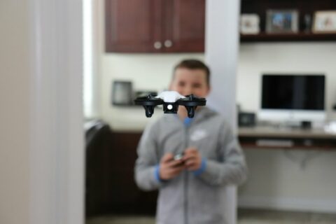 Niño pilotando un minidron en casa